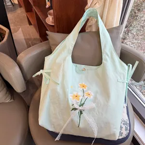 Lichtgroene nylon schoudertas met zoete bloemenborduurwerk en kanten strik voor dames.