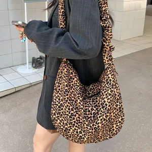 Gedetailleerd overzicht van de stijlvolle ribfluwelen crossbodytas met luipaardprint.