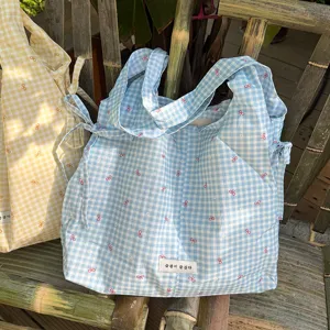 Gedetailleerd overzicht van de schattige blauw-gele ruitjes vest tote tas met strikjes.