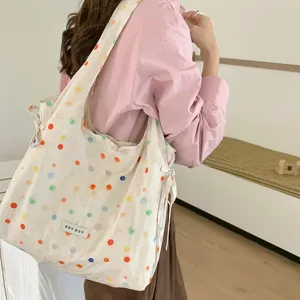 Ruime canvas tote tas met kleurrijke stippenprint en zijbandjes voor dagelijks gebruik.