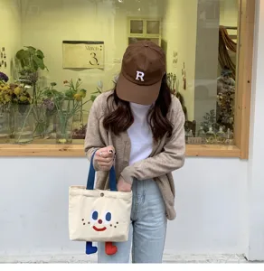 Sac bento en toile mignon avec des jambes pendantes drôles et un visage brodé, sac à lunch.