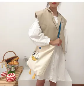 Canvas tote bag with cute cartoon duck graphic, large capacity casual shoulder bag for daily use.