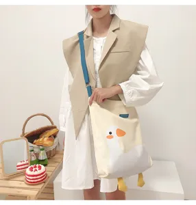 Canvas tote bag with cute duck print and blue strap, casual daily shoulder bag detail view.