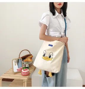 Canvas tote bag with cute cartoon duck design, large capacity casual shoulder bag for daily use.