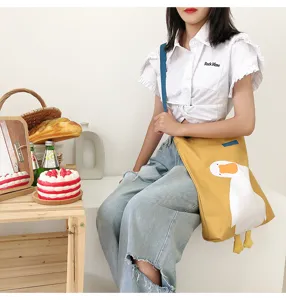 Cute yellow canvas shoulder bag with adorable duck design and large capacity for casual use.