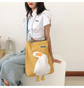 Detailed view of casual canvas shoulder bag with cute duck graphic and hanging feet.