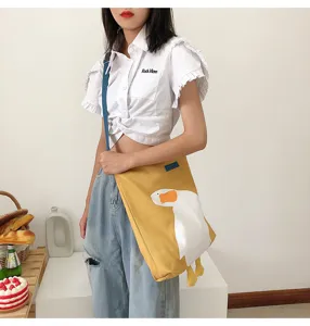 Casual yellow canvas shoulder bag with cute white goose graphic and large capacity for daily use.