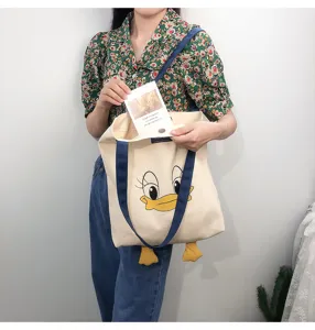 Canvas tote bag with cute cartoon duck print and color block straps, casual shoulder bag detail