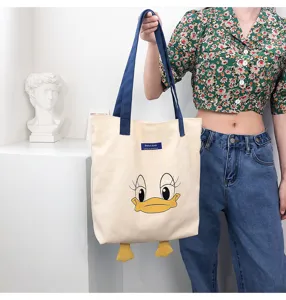 Detail view of the canvas tote bag showing the cute duck face graphic and blue handles.