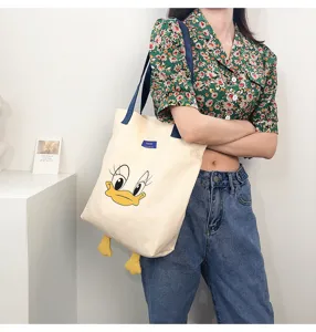 Large capacity canvas shoulder bag with cute cartoon duck face design for casual daily use.