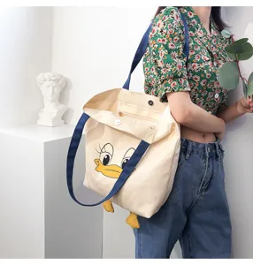 Canvas tote bag with cute cartoon duck design, large capacity shoulder bag for daily casual use.