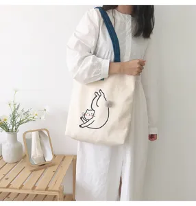 Canvas tote bag lifestyle detail shot showcasing cute cat print and shoulder strap design.
