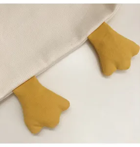 Close-up detail shot of cute canvas tote bag featuring playful 3d yellow duck feet design.