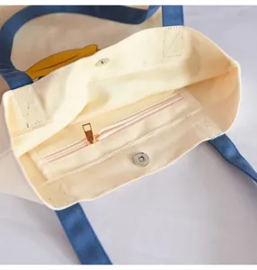 Interior detail of casual canvas tote bag with zipper pocket and magnetic snap closure.
