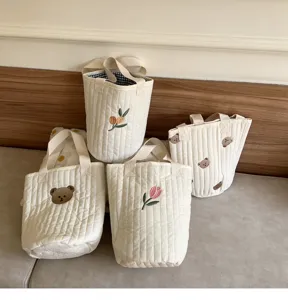 Detailed view of quilted cotton bucket bags with cute bear and tulip embroidery designs.