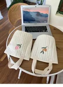 Detailed close-up of cute quilted embroidered tote bags featuring tulip and olive patterns.