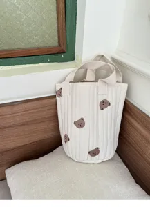 Detailed close-up shot of the quilted canvas bucket bag featuring cute bear embroidery.