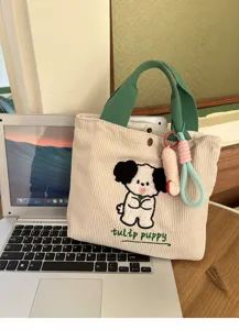 Detailed shot of a cute beige corduroy tote bag featuring green handles and sweet puppy design.