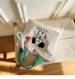 Cute corduroy embroidered tote bag with puppy design and green handles for daily use.