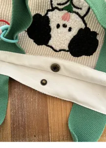 Close-up detail of cute corduroy tote bag showing fluffy animal embroidery and metal snap.