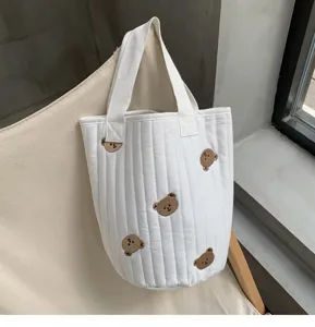 Detailed view of the cute quilted canvas bucket bag with sweet brown bear embroidery.