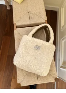 Detailaufnahme der flauschigen Sherpa-Tasche in Creme mit braunem Innenfutter und Label.