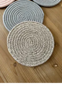 Detailed shot of woven cotton rope coasters showing intricate circular spiral texture.
