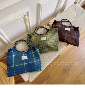 Detail shot of stylish plaid cotton shoulder bag, large capacity cradle handbag design.