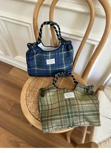 Detailed shot of casual plaid fabric tote bags with strap handles, styled nicely on chair.