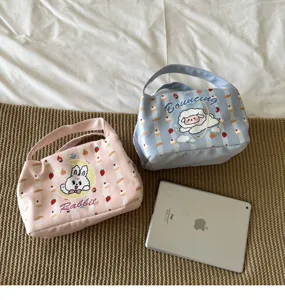Detailansicht der Leinen-Lunchtaschen mit niedlichen Hasen- und Schafdrucken für den Büroalltag.