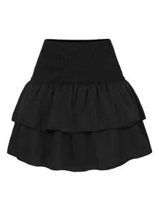 Dettaglio gonna nera a balze, primo piano della fascia in vita elastica arricciata.