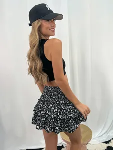 Vista dettagliata di minigonna a balze floreali, fantasia bianco e nero per donne alla moda.