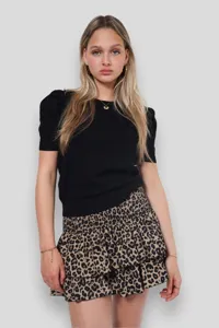 Elegante minigonna con stampa leopardata e volant da donna abbinata a top nero chic.