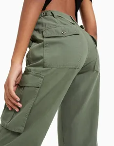 Nahaufnahme der olivgrünen Cargo-Hose mit hohem Bund, praktischen Taschen und Knöpfen.