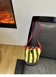 Nahaufnahme des Retro gestreiften Canvas Eimerbeutels an einem modernen Ledersessel.