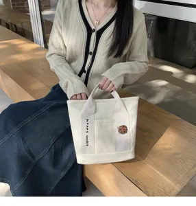 Canvas tote bag with cute cookie embroidery and webbing strap for daily casual use.