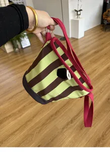 Detailansicht der Vintage gestreiften Canvas-Eimerentasche mit rosa Trägern und Design.