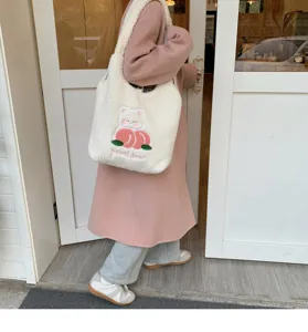 Detail shot of fluffy plush shoulder bag with cute peach bear embroidery for daily use.