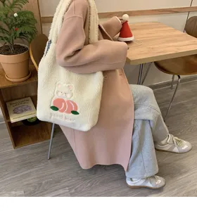Detailed view of the cute plush tote bag with embroidered peach and bear design for winter.