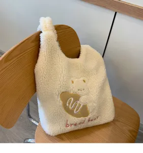Cozy cream fuzzy shoulder bag detail, cute bear toast embroidery, soft sherpa material.