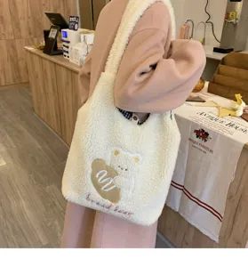 Fluffy sherpa shoulder bag for women, cute plush tote with bear embroidery for winter daily.