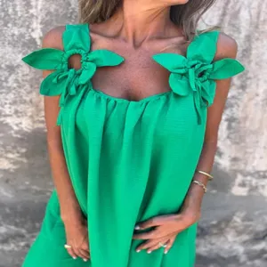 Detailed view of the vibrant green summer dress featuring unique fabric flower shoulder straps.