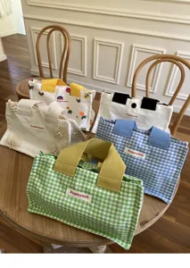 Detailed shot of multi-style mini canvas tote bags with plaid, embroidery and cute design.