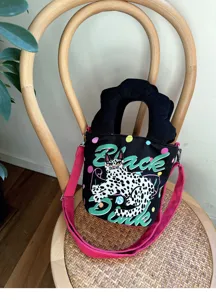 Borsa a secchiello in tela con illustrazione di gatto, manico smerlato e tracolla rosa