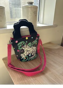 Borsa secchiello in tela con illustrazione di gatto, manico a nuvola e tracolla rosa.