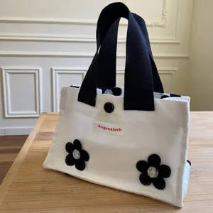 White canvas mini handbag with black handles and cute black flower appliques for daily use.