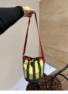 Stilvoller Canvas Beutel mit gestreiftem Muster, Tunnelzugverschluss und rotem Schultergurt.