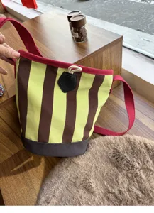 Gestreifte Canvas-Eimer-Umhängetasche mit roten Riemen und stilvollem Retro-Design für Damen.