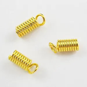 Gold spring end cap detail showing the coiled metal wire design and attached jump ring for jewelry.