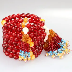 Red crystal car hanging pendant detail showing multi-layer Buddhist beads and tassels.